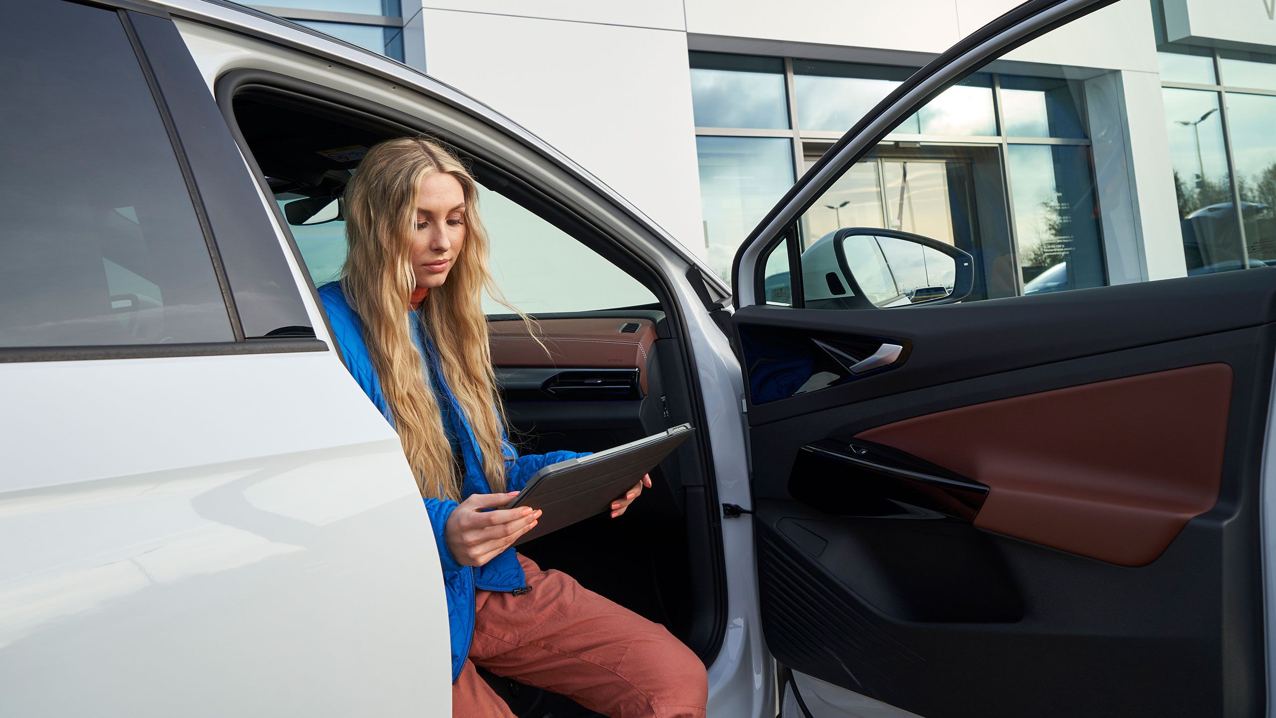 Pohled shora na Volkswagen ID. Žena se opírá o kaputu.