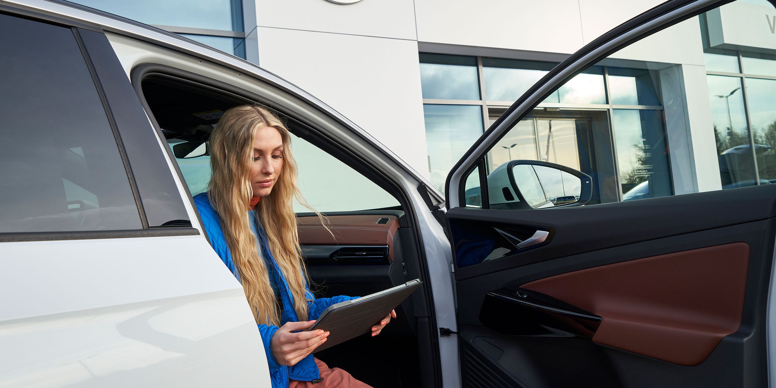 Pohled shora na Volkswagen ID. Žena se opírá o kaputu.